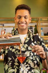 a man pouring a drink into a martini glass at Hostal Seven Nights Cartagena in Cartagena de Indias