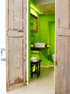 una porta aperta che conduce a un bagno verde con lavandino di Mia House - Alloggio da sogno a Civitanova Alta a Civitanova Alta