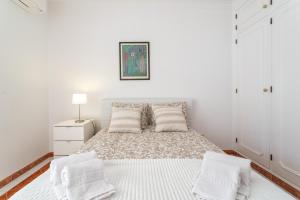 a white bedroom with a bed with two pillows at Host Wise - Amazing Sunny Flat - Swimming Pool & Terrace in Vilamoura