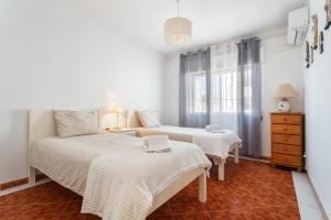 a bedroom with two beds and a window at Host Wise - Amazing Sunny Flat - Swimming Pool & Terrace in Vilamoura