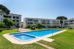 an image of a swimming pool in front of a building at Host Wise - Amazing Sunny Flat - Swimming Pool & Terrace in Vilamoura +28 photos