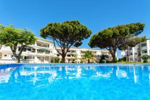 a large swimming pool in front of a building at Host Wise - Amazing Sunny Flat - Swimming Pool & Terrace in Vilamoura