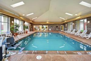 una piscina en un hotel con sillas y mesas en Homewood Suites by Hilton Lancaster en Lancaster