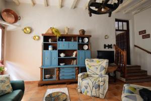 a living room with a blue cabinet and a chair at tuGuest Hortichuela House in Ugíjar