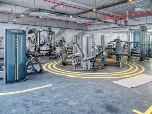 een fitnessruimte met cardio-apparatuur en een muur met graffiti bij Exquisite 1 BDR apt in the heart of Dubai Marina- Studio One Tower in Dubai