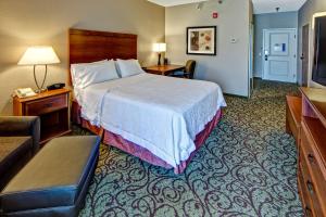 a hotel room with a bed and a couch at Hampton Inn Laurinburg in Laurinburg