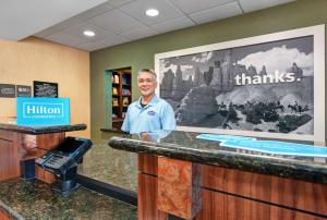 a man standing at a counter in a pharmacy at Hampton Inn Deming in Deming