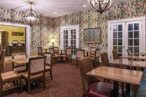 un restaurante con mesas y sillas y papel pintado con motivos florales en Hampton Inn Lexington Historic Area en Lexington
