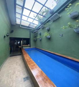a swimming pool in a building with a window above it at Hostal Seven Nights Cartagena in Cartagena de Indias