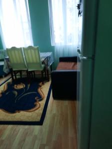 a living room with two chairs and a rug at Homestay Izolda in Batumi