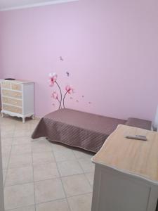 1 dormitorio con 1 cama con flores en la pared en Appartamento Giulia, en Muravera