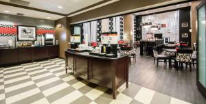 a restaurant with a counter and a dining room at Hampton Inn & Suites Orlando-John Young Parkway/South Park in Orlando