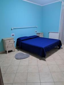 Dormitorio azul con cama y mesita de noche en Appartamento Giulia, en Muravera