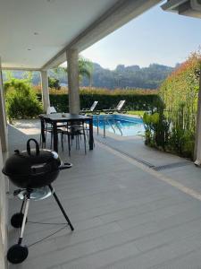 un patio con parrilla, mesa y piscina en Casa Natalia, en Vila Nova de Famalicão