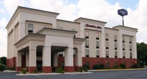 a white building with a sign on top of it at Hampton Inn Inwood in Inwood