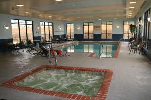 une grande piscine avec des chaises et des tables dans un bâtiment dans l'établissement Hampton Inn & Suites McComb, à McComb
