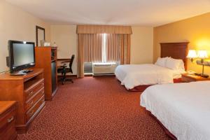 Hampton Inn & Suites McComb في ماكومب: غرفة فندقية بسريرين وتلفزيون بشاشة مسطحة