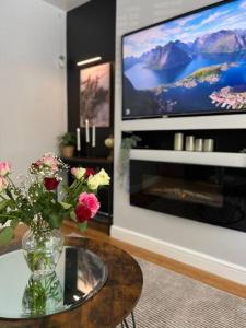a vase of flowers on a table in a living room at Stylish home close to Arena in Wincobank