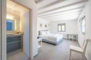 a white bedroom with a bed and a sink at Villa Tholos -Athens Riviera in Kalívia Thorikoú