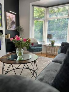 a living room with a vase of flowers on a table at Stylish home close to Arena in Wincobank