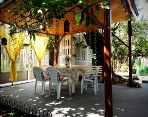 une table et des chaises blanches sous un kiosque dans l'établissement Jenny's House, à Yerakiní