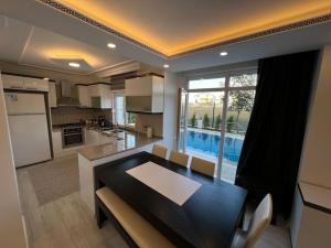 a kitchen and dining room with a table and a large window at Villa ateş in Belek