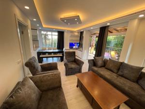 a living room with a couch and chairs and a piano at Villa ateş in Belek