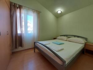 Dormitorio pequeño con cama y ventana en Apartmani Toni Vodice, en Vodice