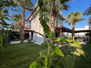 una casa con palmeras delante en Villa ateş, en Belek