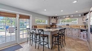 a kitchen with a large island with bar stools at Decked Out on Marbury in Longboat Key