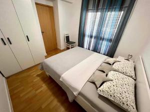 a bedroom with a bed and a large window at Apartments Possedaria in Posedarje