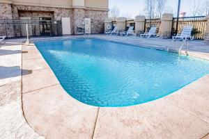 a swimming pool with chairs in a building at Hampton Inn Montgomery-South-Airport in Hope Hull