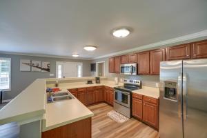 a kitchen with wooden cabinets and stainless steel appliances at Guntersville Lake House Dock and Boat Ramp Access! in Scottsboro