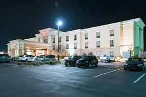 un hotel con coches estacionados en un estacionamiento por la noche en Hampton Inn Montgomery-South-Airport, en Hope Hull
