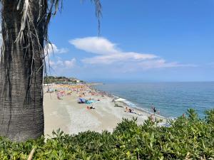 un groupe de personnes sur une plage avec l'océan dans l'établissement Due passi dal mare, à Savone