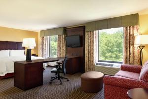a hotel room with a bed and a desk and a bed and a couch at Hampton Inn & Suites Prattville in Prattville
