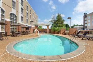 uma piscina num hotel com cadeiras e mesas em Hampton Inn & Suites Montgomery-EastChase em Montgomery