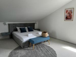 a bedroom with a large bed with a blue stool at Vitas Apartments in Zaton