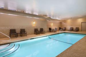 a pool with chairs and tables in a hotel room at Hampton Inn & Suites Exeter in Exeter