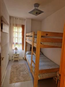 a small room with two bunk beds and a window at Apartamentos Bon Amb in Faro de Cullera