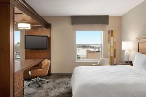 a hotel room with a bed and a desk and a television at Hampton Inn & Suites Exeter in Exeter