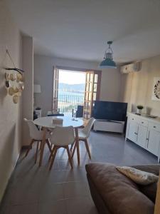 a living room with a table and chairs and a couch at Apartamentos Bon Amb in Faro de Cullera