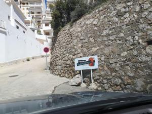 a sign on the side of a stone wall at Apartamentos Bon Amb in Faro de Cullera