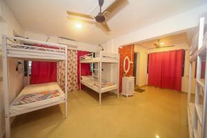 een kamer met 2 stapelbedden en een plafondventilator bij Hostell One - A complete backpacker & Coworking Hub in Pune