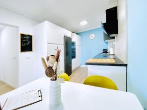 uma cozinha com paredes brancas e azuis e cadeiras amarelas em Casa Natura Sunset Beach em Gran Alacant