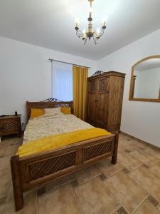 um quarto com uma cama, um espelho e um lustre em Agroturystyka Galant em Połęczyno