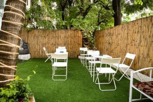een rij witte tafels en stoelen op het gras bij Hostell One - A complete backpacker & Coworking Hub in Pune