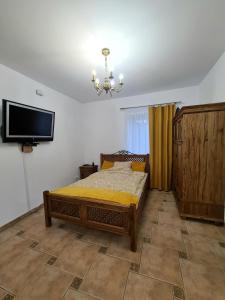 a bedroom with a bed and a flat screen tv at Agroturystyka Galant in Połęczyno