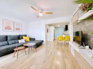 uma sala de estar com um sofá azul e cadeiras amarelas em Casa Natura Sunset Beach em Gran Alacant