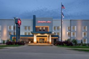 una vista frontal de un hotel con bandera americana en Hampton Inn Kansas City Blue Springs, en Blue Springs